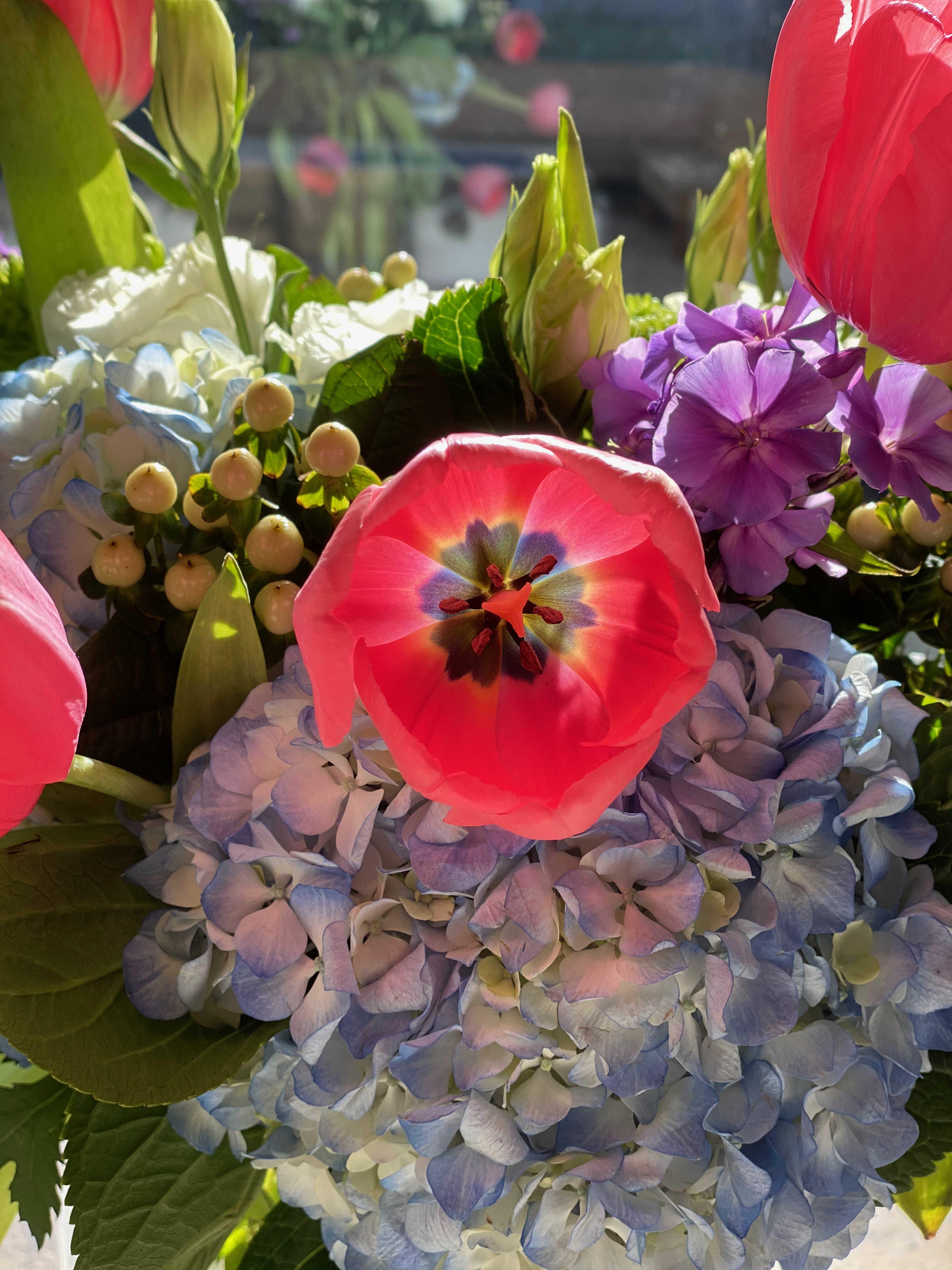 A bouquet of flowers, with a large pink one at the center.